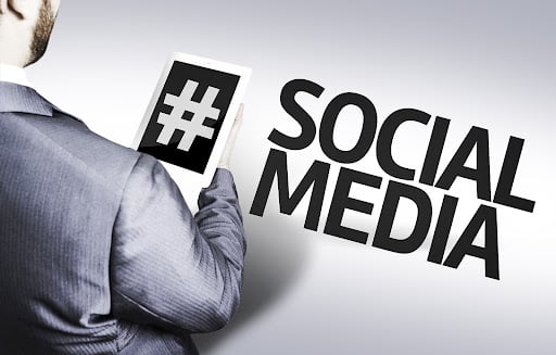 Business professional holding a tablet with hashtag symbol representing dental social media marketing ideas