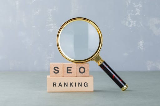 Magnifying glass over SEO ranking blocks representing a different type of seo