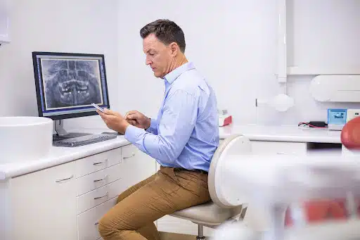 Orthodontist reviewing digital records on a tablet showcasing SEO necessity for orthodontist