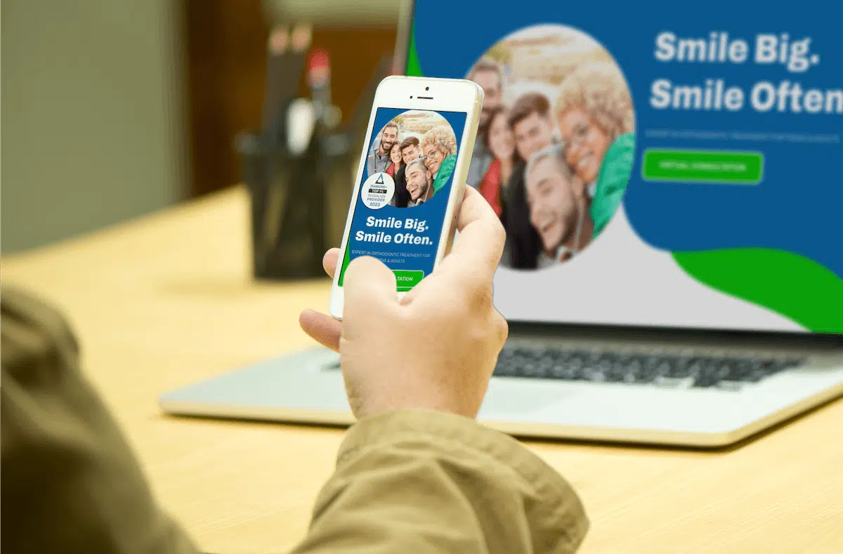 Orthodontic patient using a smartphone in a dental office showing a clear website design benefit on mobile devices