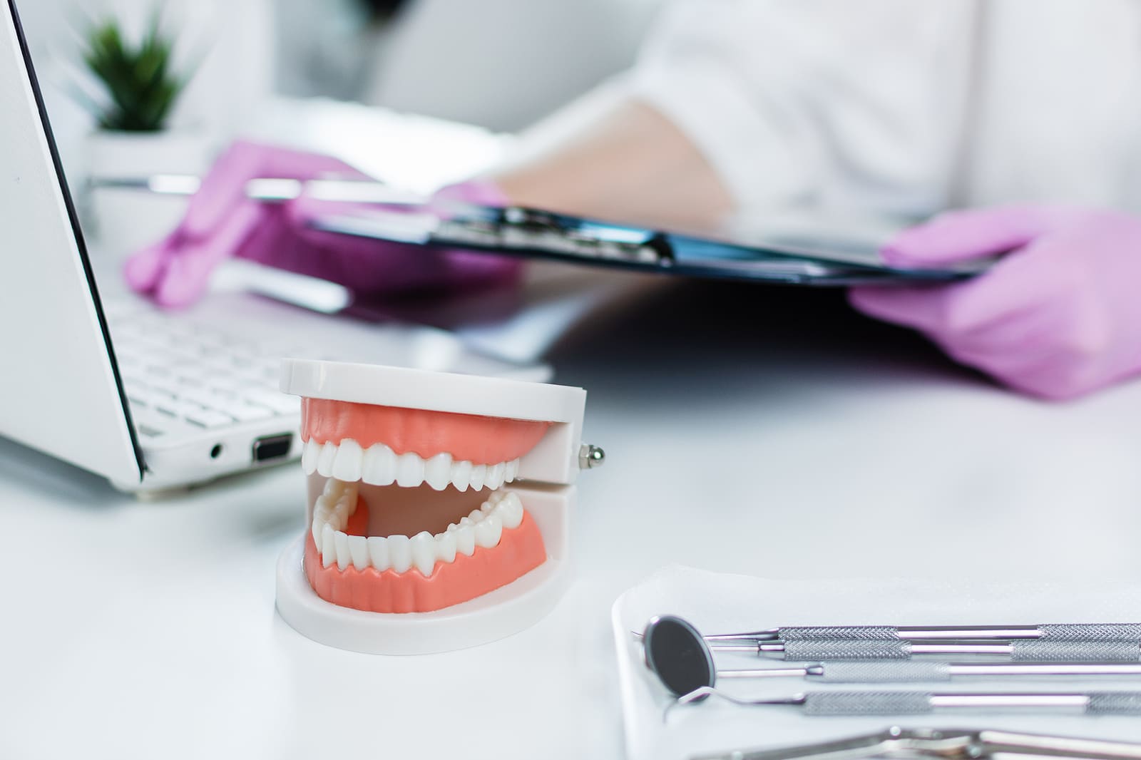 Dental model and tools near computer representing orthodontic marketing automation in a clinical setting