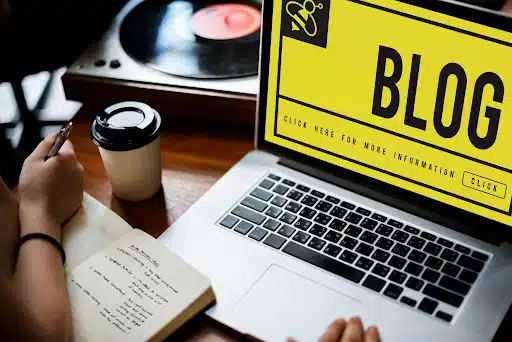Blogger writing notes beside laptop screen highlighting blog strategy and a structured content development plan
